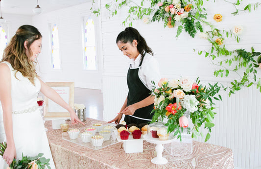 Woman serves cupcake at custom wedding cupcake bar in Austin, Texas