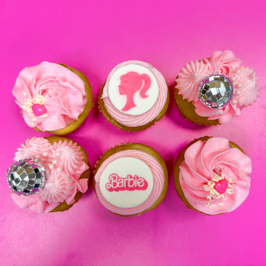 Limited Edition Barbie cupcakes. Includes 6 Vanilla cupcakes with vanilla buttercream, edible fondant toppers, and Barbie-inspired toppings. Available for pickup and delivery in Austin, Texas.